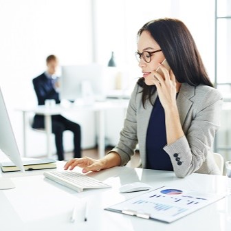Businesswoman speaking on the phone and browsing online Businesswoman speaking on the phone and browsing online